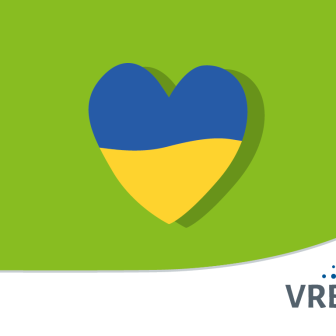 Ein Herz in den Farben der ukrainischen Flagge vor grünem Hintergrund.