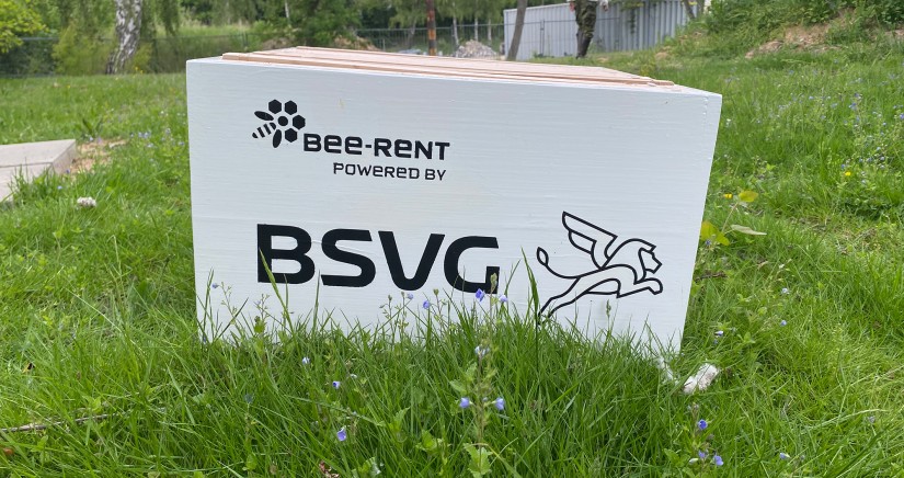 Ein weiß lackierter Bienenstock der Firma Bee-Rent mit dem Logo der BSVG steht auf einer Wiese auf dem Betriebshof der BSVG.