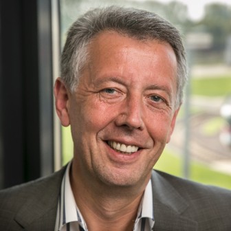 Jörg Reincke, Geschäftsführer des VRB, trägt ein weißes Hemd und ein graues Jackett und lächelt in die Kamera.