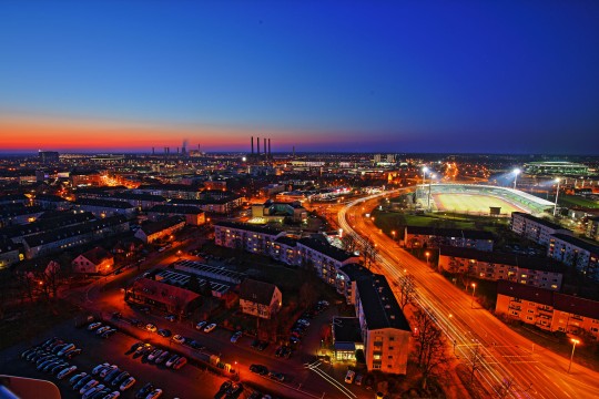 Luftaufnahme der Stadt Wolfsburg bei Nacht.
