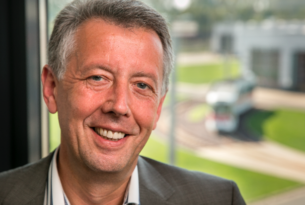 Jörg Reincke, Geschäftsführer des VRB, trägt ein weißes Hemd und ein graues Jackett und lächelt in die Kamera.