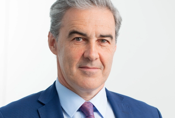 Ralf Sygusch, Geschäftsführer des VRB, trägt einen blauen Anzug und eine lilafarbene Krawatte und lächelt in die Kamera.